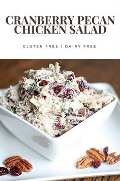 cranberry pecan chicken salad is served in a white bowl with pecans on the side