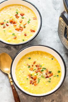 two bowls filled with soup sitting next to an instant pressure cooker and spoons