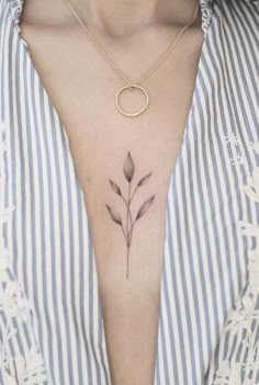 a woman's chest with a small flower tattoo on her left side ribcage