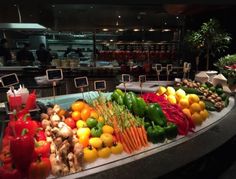 an assortment of fruits and vegetables on display in a buffet area at a restaurant or bar