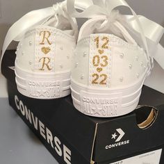 a pair of white sneakers with gold sequins on them