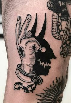 a man's leg with tattoos on it and an image of a hand holding a skull