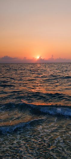 the sun is setting over the ocean with waves