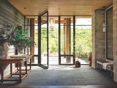 the inside of a house with large glass doors and stone walls on either side of the room