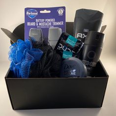 an open box containing men's grooming products and hair care items on a white surface