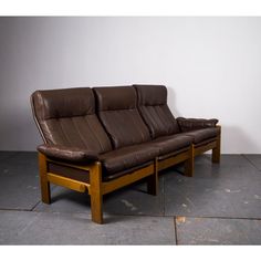 a brown leather couch sitting on top of a wooden frame