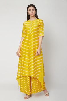 Sunshine yellow high-low kurta with all-over leheriya print. Paired with bandhej print palazzo pants.
Component: 2
Printed
Neckline: Round
Sleeve Length: Half
Fabric: Modal Satin
Color: Yellow
Asymmetric hem
Detailing at neck and sleeves
Long kurta - Aza Fashions Yellow Kurta Sets For Women, Lehriya Kurti Designs, Bandhni Kurti Designs Latest, Lehariya Kurti Designs, Haldi Dresses, Haldi Wedding, Printed Kurti Designs, Simple Kurtis, Yellow Kurti