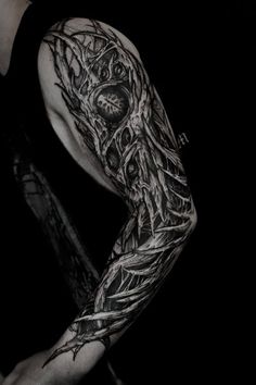 a man's arm covered in black and white ink with an intricate tattoo design