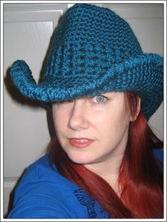 a woman with red hair wearing a blue hat