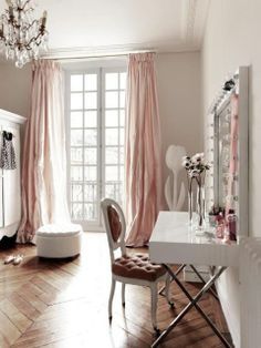 a bedroom with a chandelier, dresser and mirror