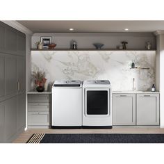 the front load washer and dryer are shown in this kitchen with white cabinets