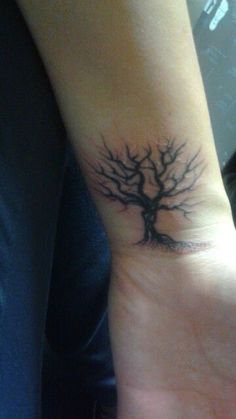 a person's wrist with a tree tattoo on it