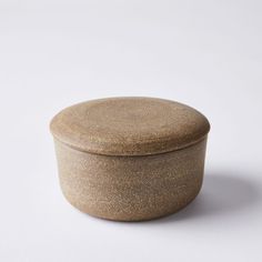 a round ceramic container sitting on top of a white surface