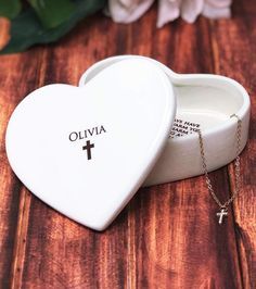 a white heart shaped box with a cross on it