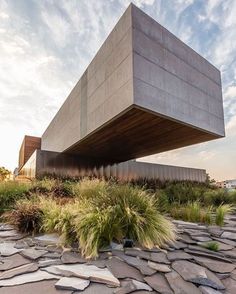 the building is made out of concrete and has grass growing on it's sides