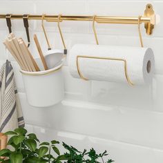 a white toilet paper holder with gold handles