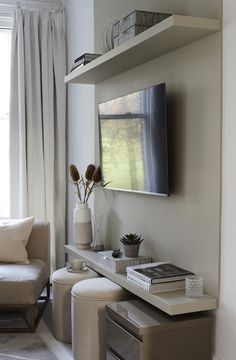 a living room filled with furniture and a flat screen tv mounted to the side of a wall