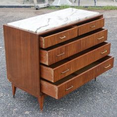 an old dresser with marble top and four drawers in the process of being restored into a modern piece of furniture