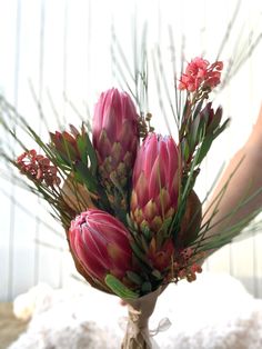 a vase filled with pink flowers on top of a bed