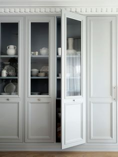 an empty white china cabinet with glass doors