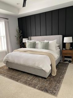 a large bed sitting in the middle of a bedroom next to a lamp and window