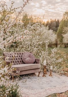 a couch sitting on top of a rug in the middle of a field