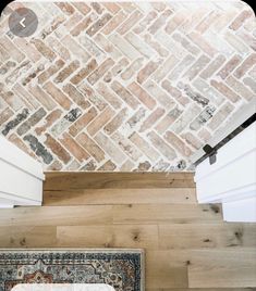 an overhead view of a living room with wood flooring and brick wall covering the walls