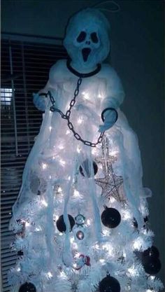 a white christmas tree with a ghost on it's head and chains around its neck