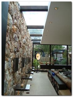 the interior of a modern house with stone walls