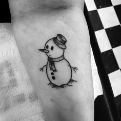 a small snowman tattoo on the left inner arm and leg, with a hat on it's head