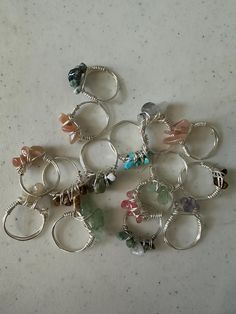 a bunch of rings that are sitting on a table together with beads and charms attached to them