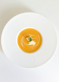 a white plate topped with an orange soup