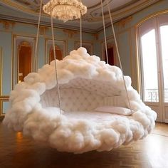 a bed made out of clouds in a room with chandelier hanging from the ceiling