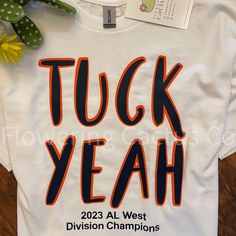 a white t - shirt that says tuck yeah with orange and black letters on it