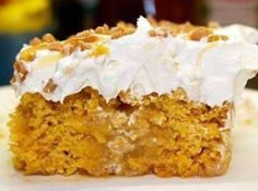 a piece of cake with white frosting and nuts on top sitting on a plate