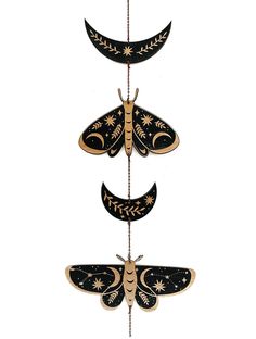 three dragonflys hanging from a string with stars and moon designs on the wings