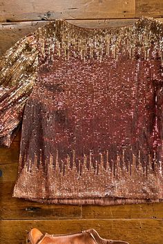 Half sleeve sequin top. From gold to copper red to rose gold. This fiery number will have you wanting to throw a party! Half puff sleeves with a hidden elastic cuff. Fully lined. Rounded neckline. 95% polyester/ 5% spandex; 100% polyester lining. Care instructions: hand wash cold with like colors, do not bleach, do not wring or twist, flat dry, cool iron if needed. Our standard young contemporary sizing. X-Small fits sizes 2-4, small fits sizes 5-7, medium fits sizes 8-10, large fits sizes 11-13 Festive Shimmer Blouse For Fall, Fall Festive Shimmer Blouse, Festive Fall Shimmer Blouse, Metallic Embellished Tops For Party, Gold Stretch Tops For Party Season, Stretch Embellished Party Blouse, Party Metallic Embellished Tops, Stretch Gold Tops For Party Season, Gold Tops For Holiday Party