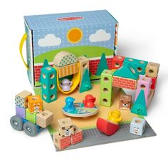 a wooden toy set sitting on top of a white floor next to a box filled with toys