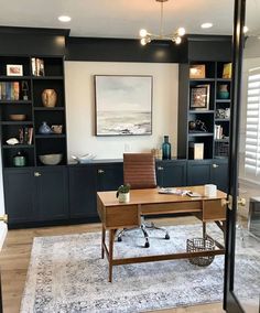 a home office with built - in bookcases and an area rug