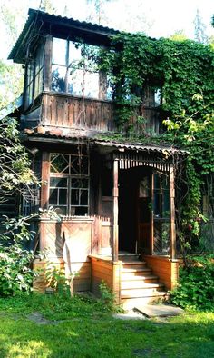 an old wooden house covered in vines and ivys