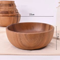 wooden bowls are stacked on top of each other, with measurements in front of them