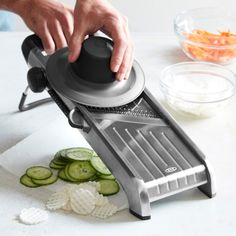 a person is using a vegetable slicer to cut cucumbers