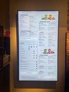 a menu is displayed on the wall in front of a brick wall with a light