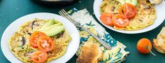 an omelet with toast, tomatoes and avocado on the side