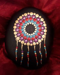 a painted rock with beads on it