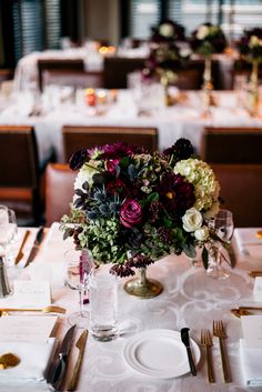 the table is set with flowers and place settings