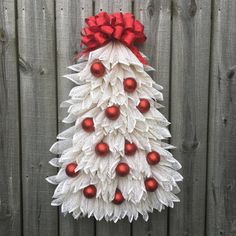 a christmas tree made out of paper with red balls and bows on it's head