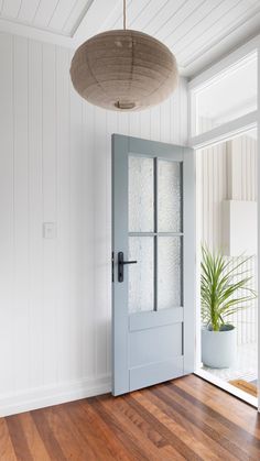 an empty room with a blue door and potted plant