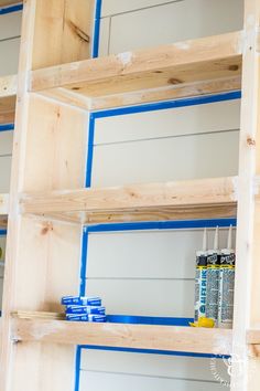 the shelves are being constructed with blue tape and some white paint on top of them