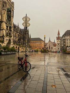 a bicycle is parked in the middle of an empty square with buildings on both sides